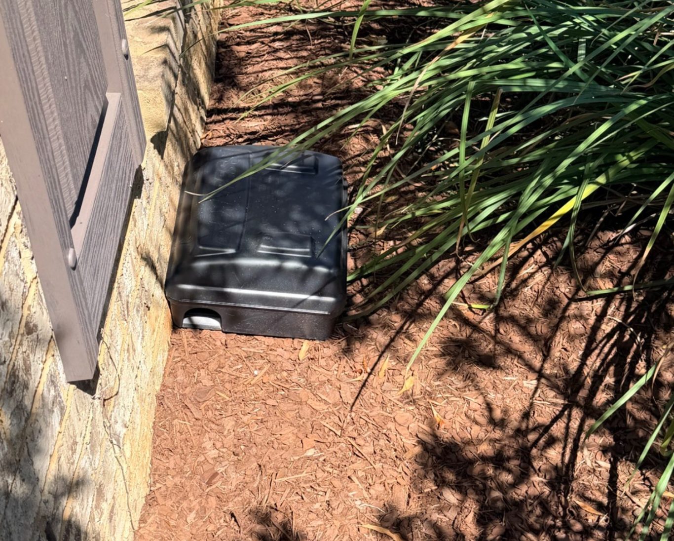 Rodent bait station placed on the outside of a Fairhope, AL home by Hilbun Pest Control
