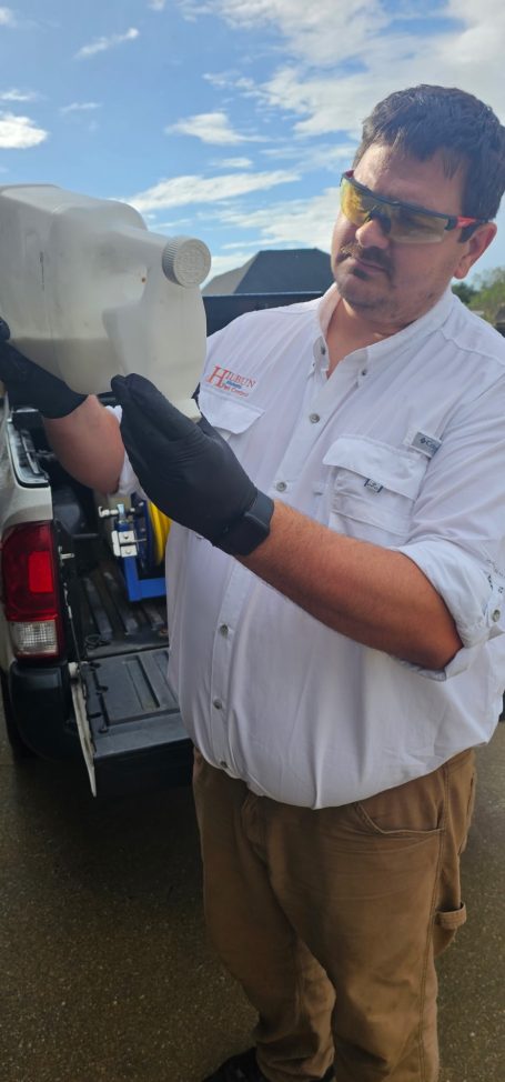 Hilbun Pest Control technician measuring bifenthrin before a residential pest control treatment.