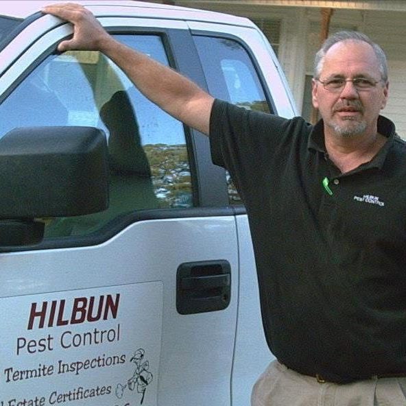 Hilbun Pest Control founder beside an early company service truck in Livingston, Louisiana.