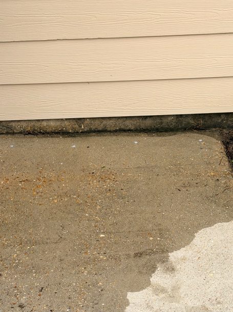 Concrete Slab Drilling for Liquid Termite Treatment Drill holes spaced 12 inches apart through a concrete slab for liquid termite treatment along a home's foundation.