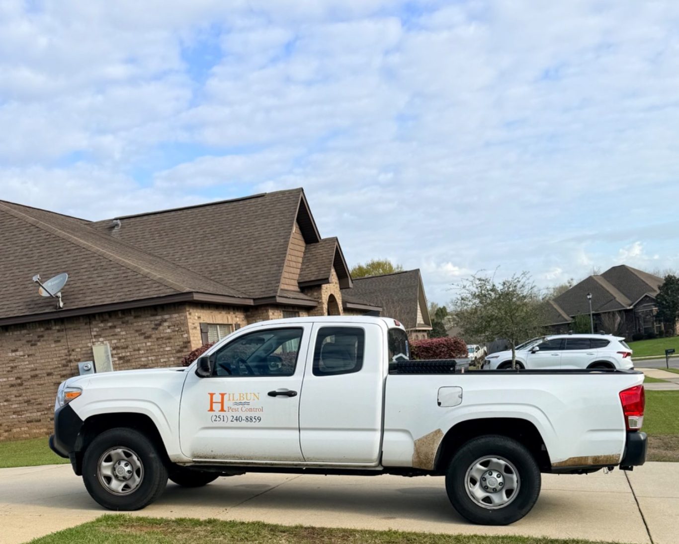 Hilbun Pest Control truck parked at Fairhope home during termite treatment 