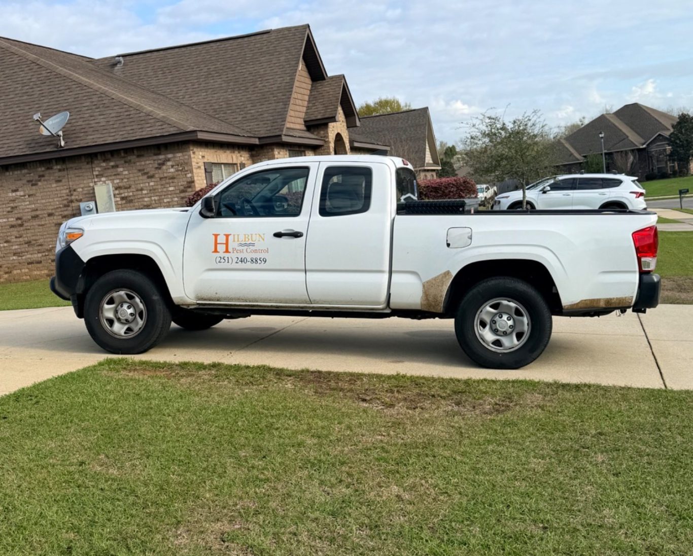Hilbun Pest Control truck parked in Fairhope, AL driveway ready to perform pest control service.