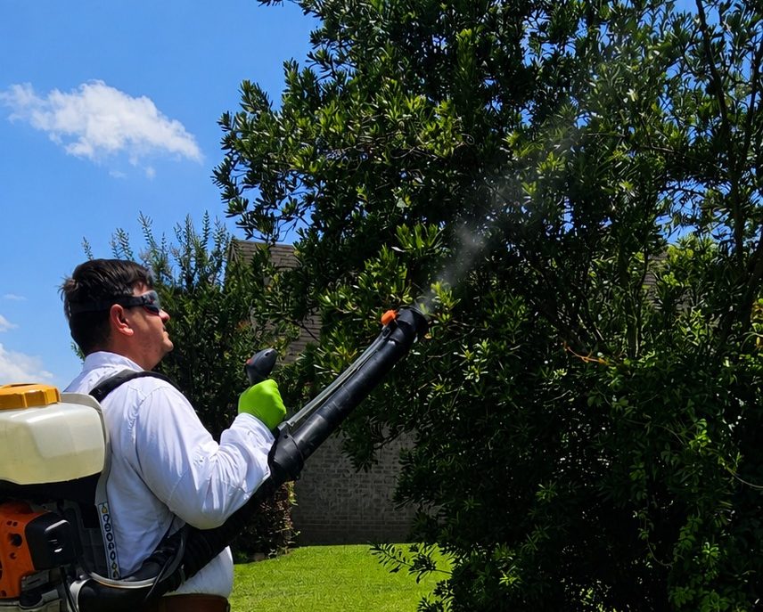 Mosquito Treatment Service in Bay Minette, Alabama | Hilbun Pest Control Hilbun Pest Control technician using a backpack fogger to treat shrubs for mosquitoes in Bay Minette, Alabama.